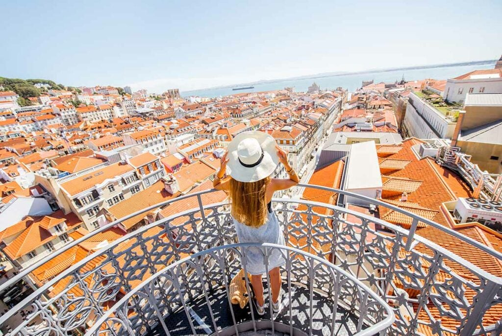 woman on balcony with rooftop view over Lisbon in portugal
